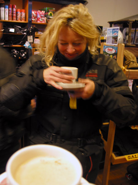 Drinking coffee, inside, in a motorcycle suit