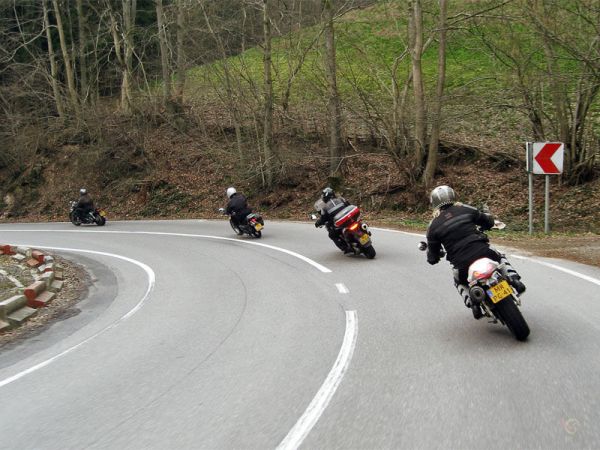 Four motorcycle riders together in a corner