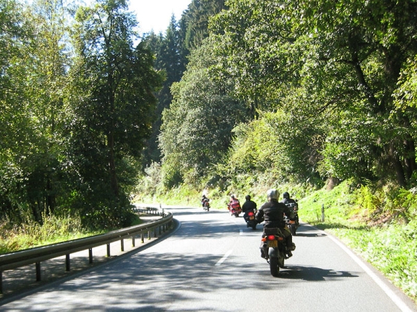 Motorcycle rider as the last in a group in a corner to the left